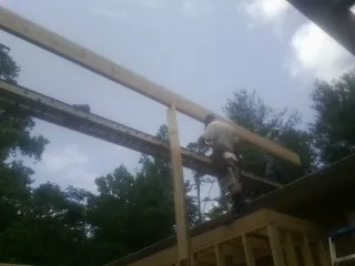 Carpenter setting a ridge beam over a new addition frame — Ice Dam Removal by Roofing Brothers in Old Town