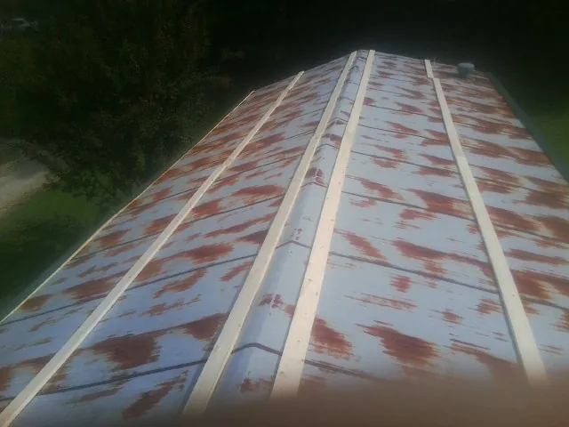 Rusted metal roof panels with new wood purlins before replacement — Storm Damage Roof Repair in Old Town by Roofing Brothers
