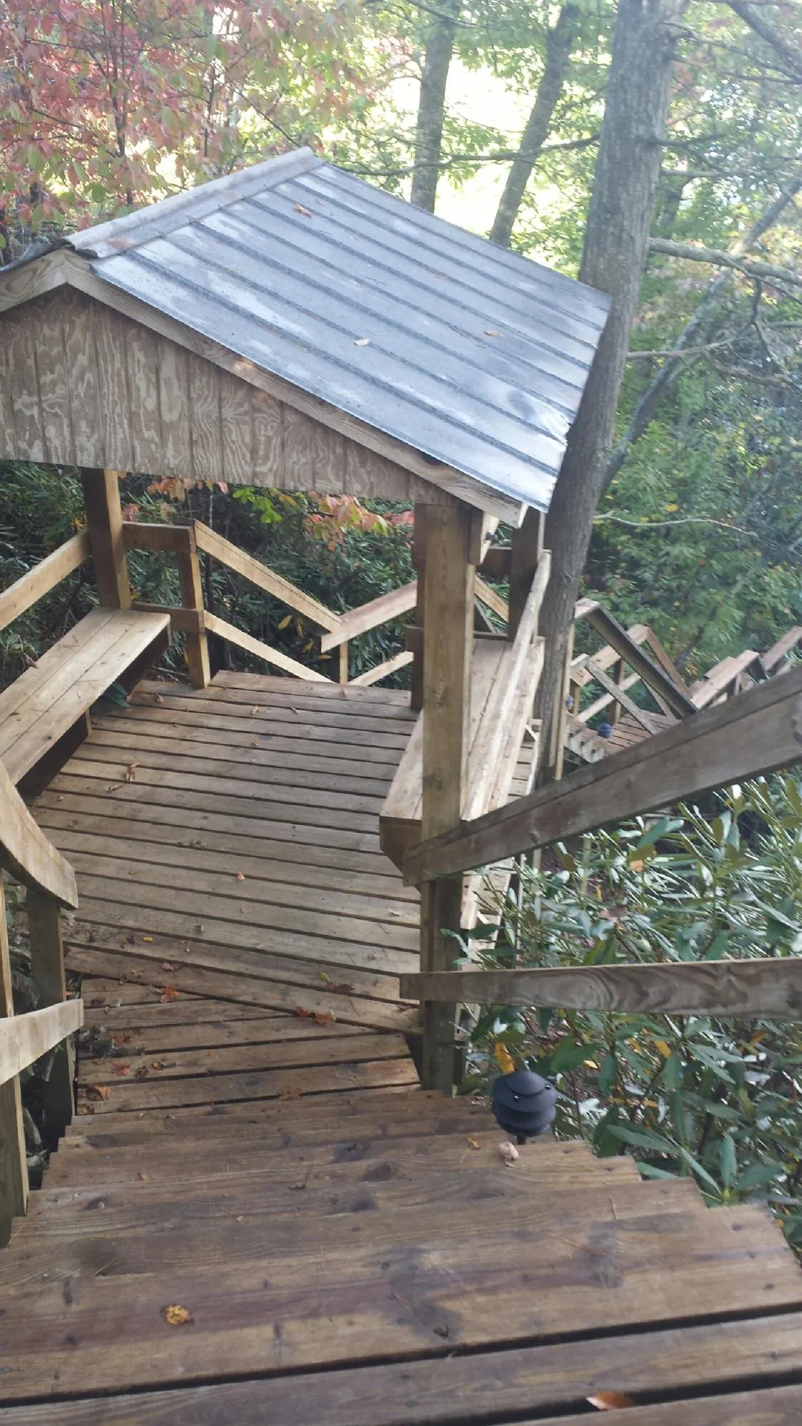 Metal roofed shelter over wooden steps on a wooded walkway — Skylight Repair & Installation work by our crew in Old Town
