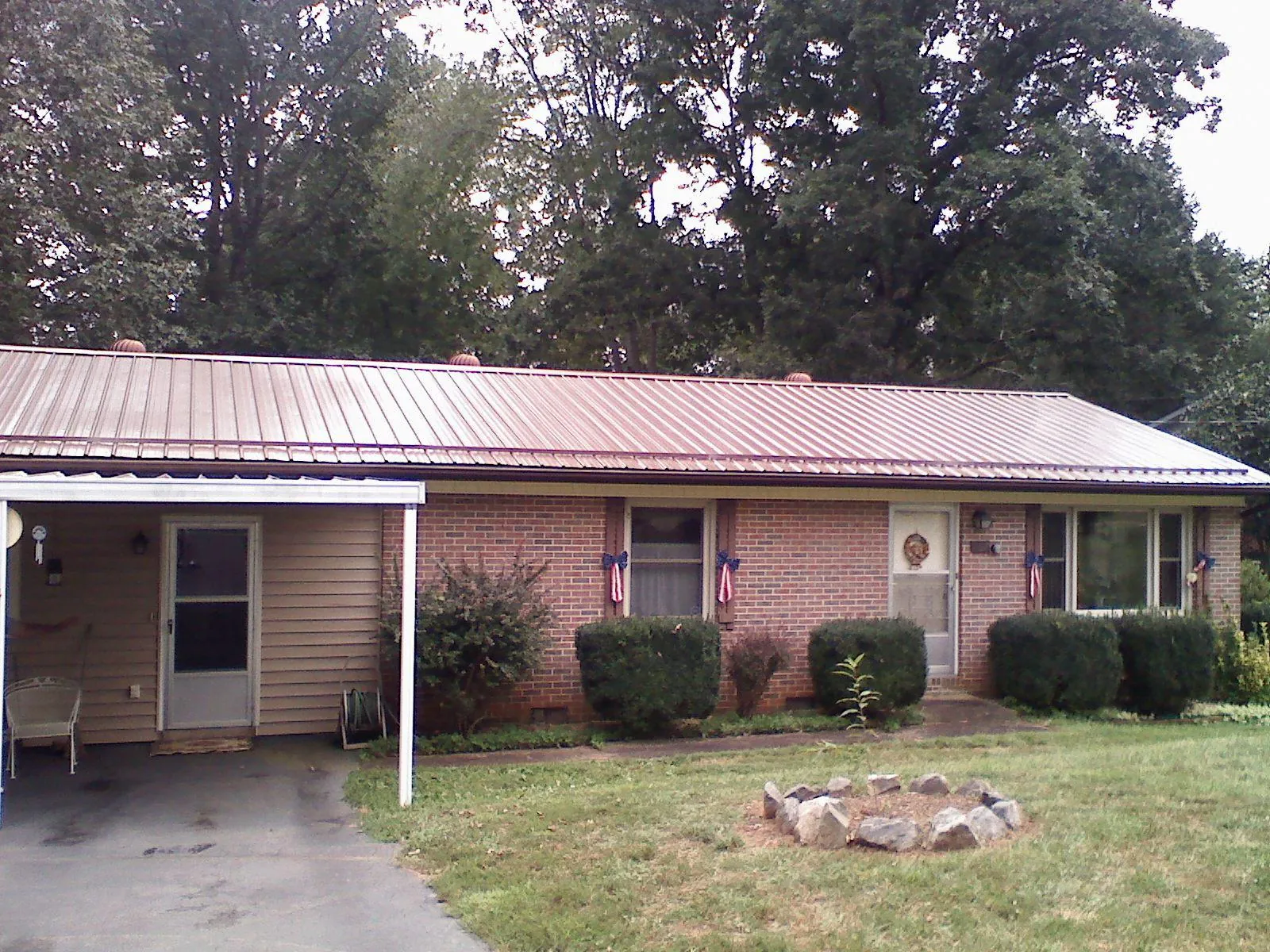 Bronze metal roof and carport on a brick ranch home — Roof Repair work by our crew in Old Town